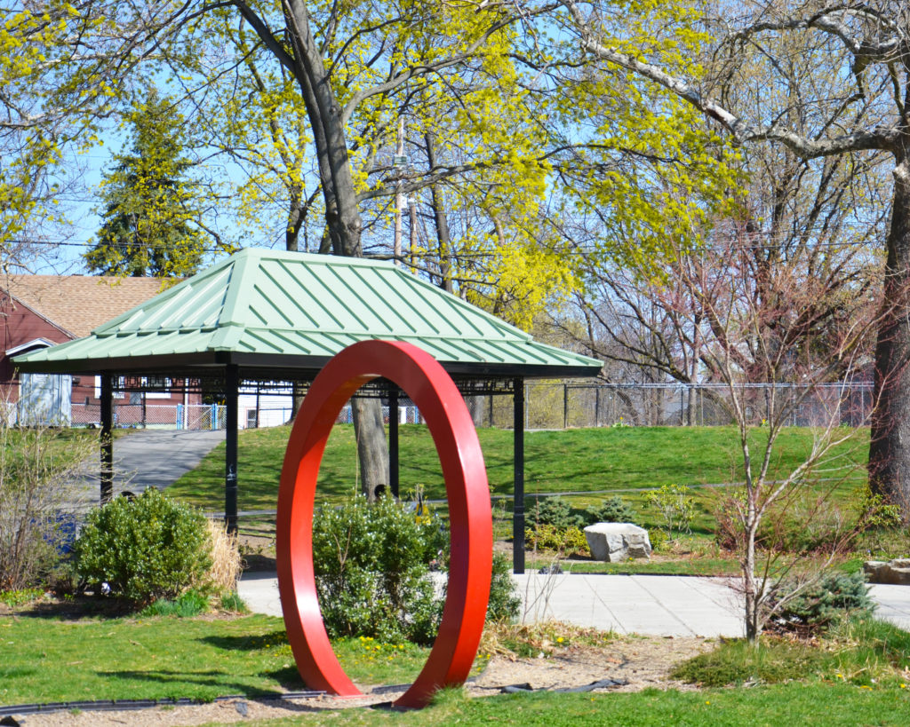A red sculpture in the middle of a park.