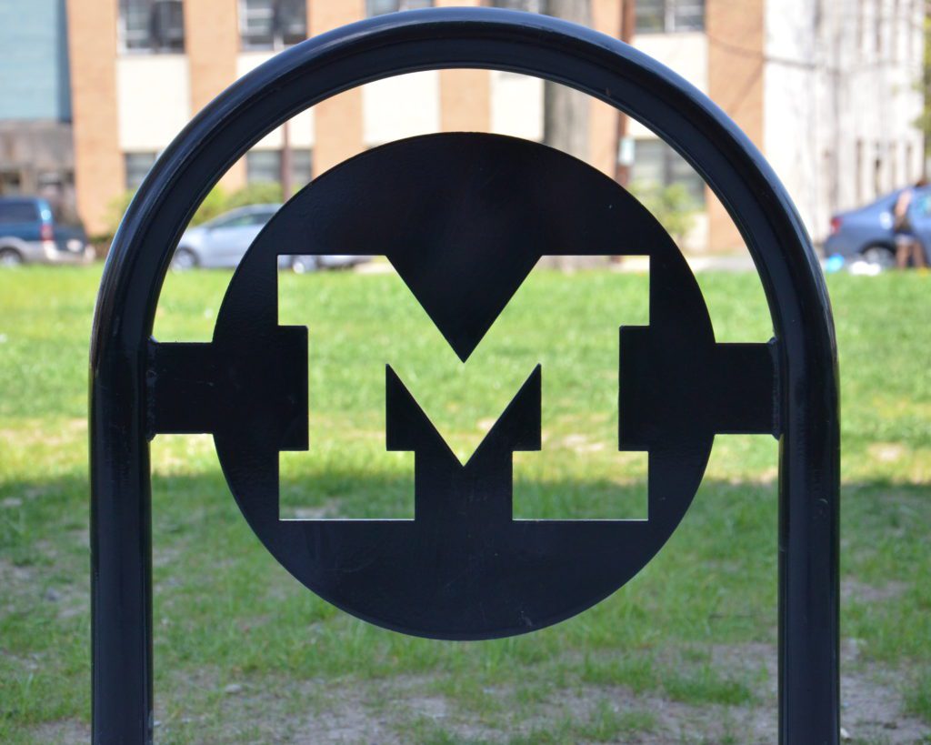 A close up of the letter m on a park bench