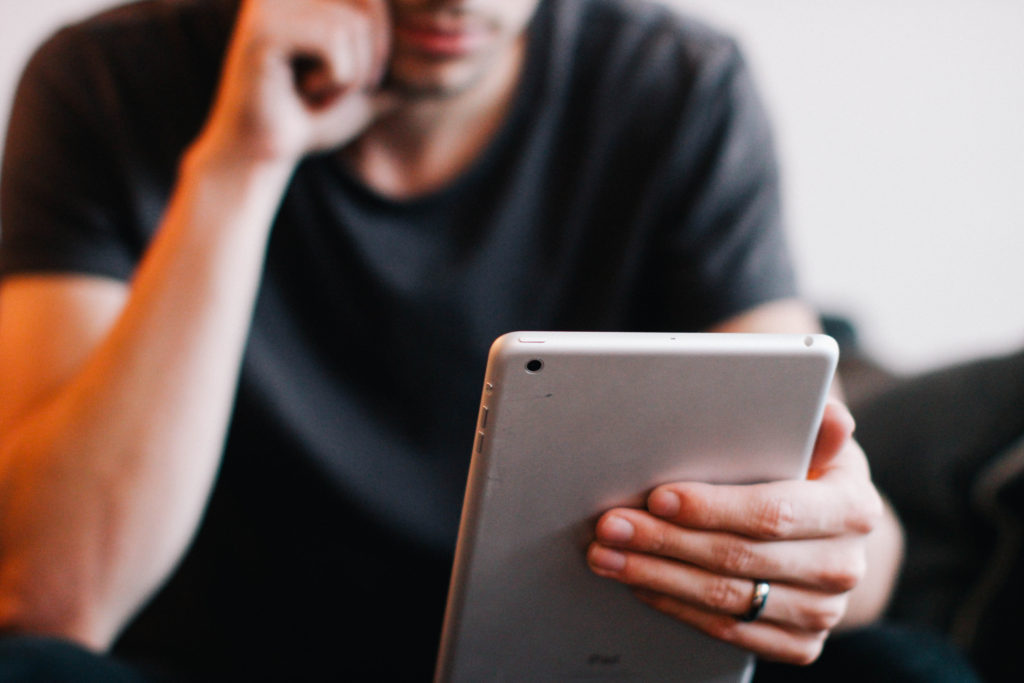 A man holding an ipad in his hand.