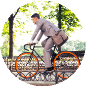 A man in grey suit riding a bike.