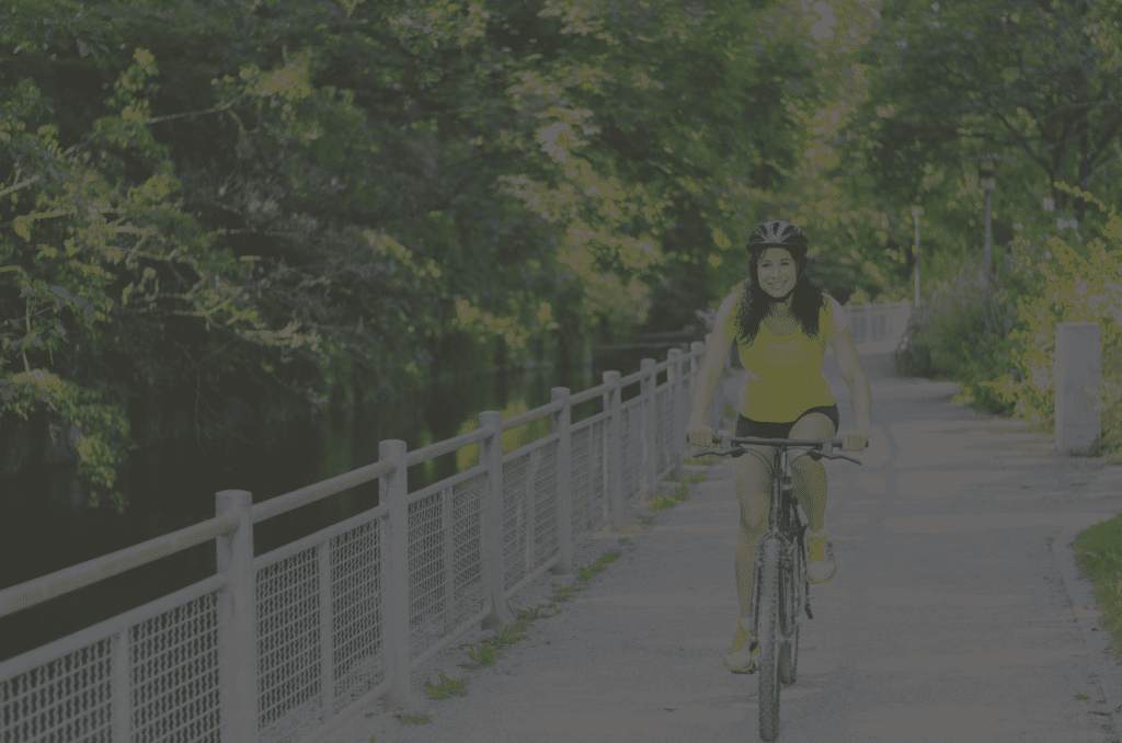 A woman riding her bike on the side of a road.