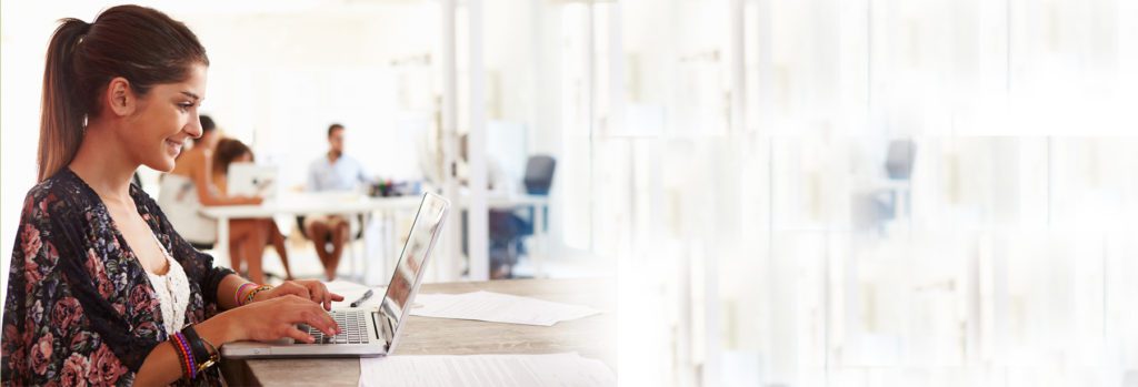 A laptop sitting on top of a wooden table.