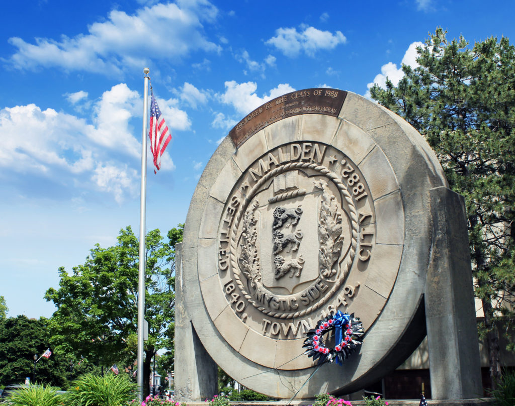 A large stone sign with a wreath on top of it.