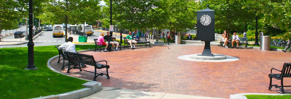 A group of people sitting on benches in the park.