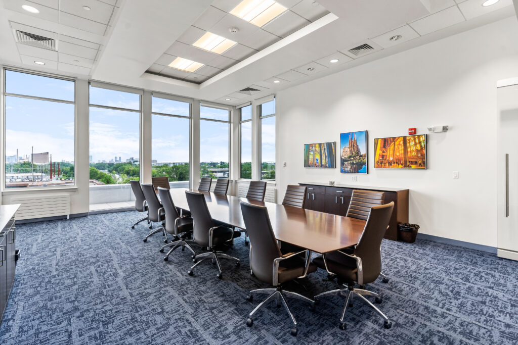 A conference room with a large table and chairs.