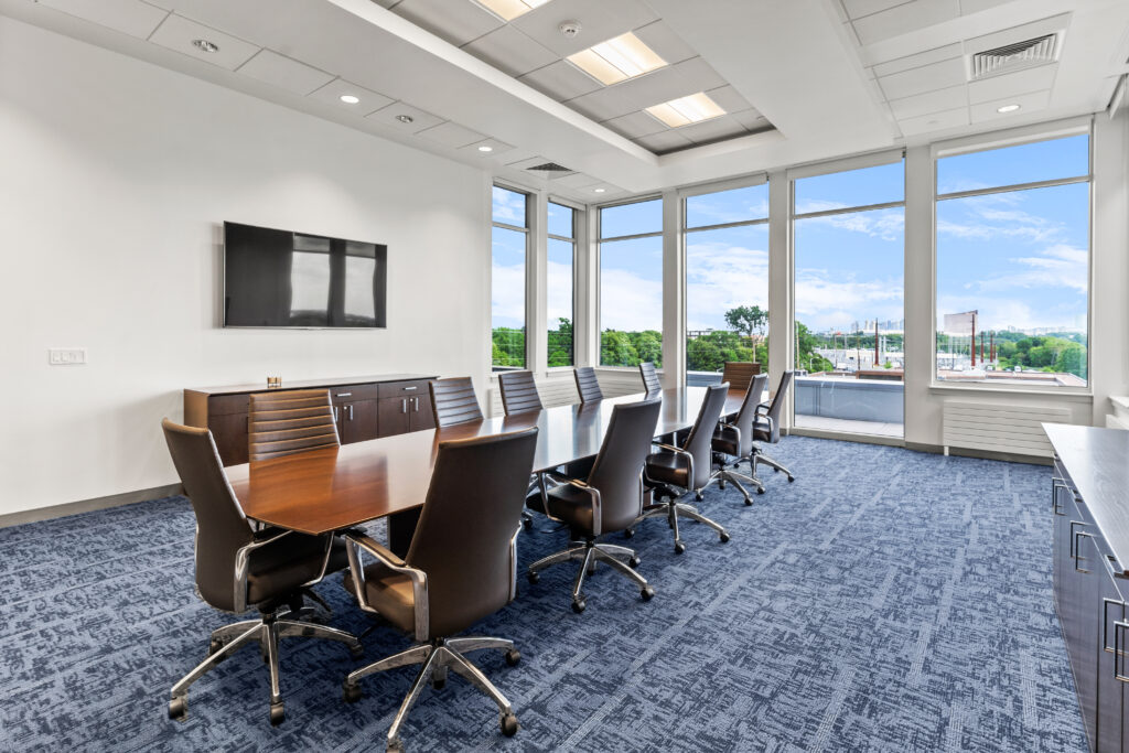 A conference room with a large table and chairs.