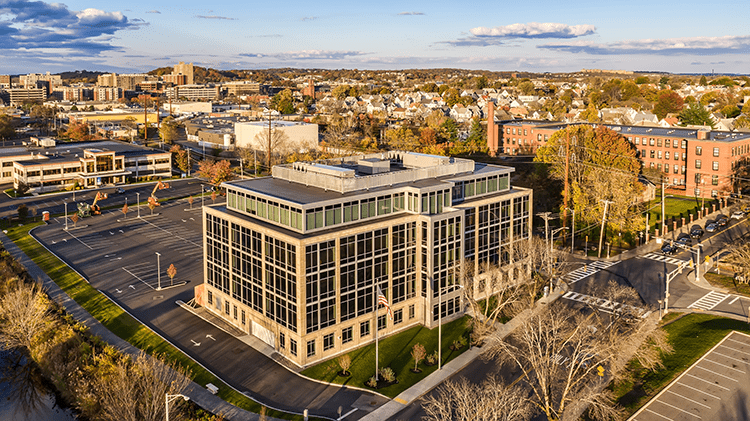 An aerial view of a building with trees in the background.