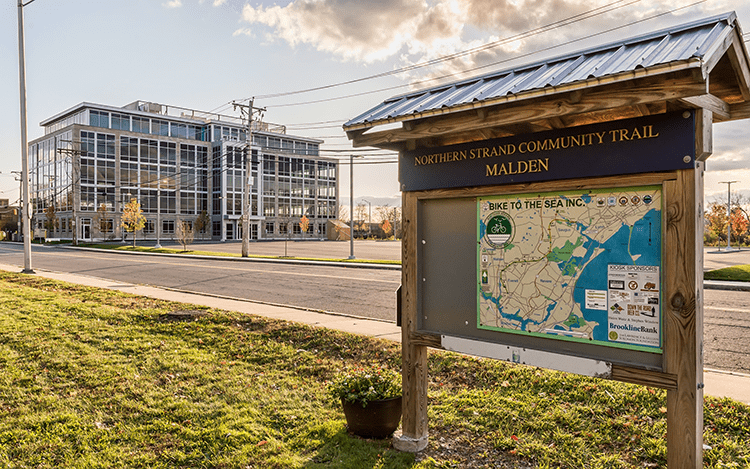 A sign in front of a building with a map on it.