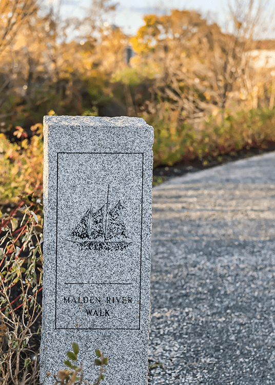 A stone sign on the side of a road.