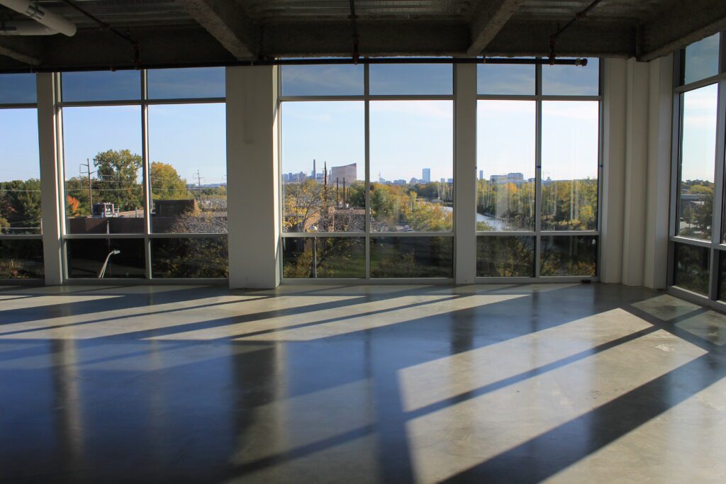 A large room with many windows and some trees