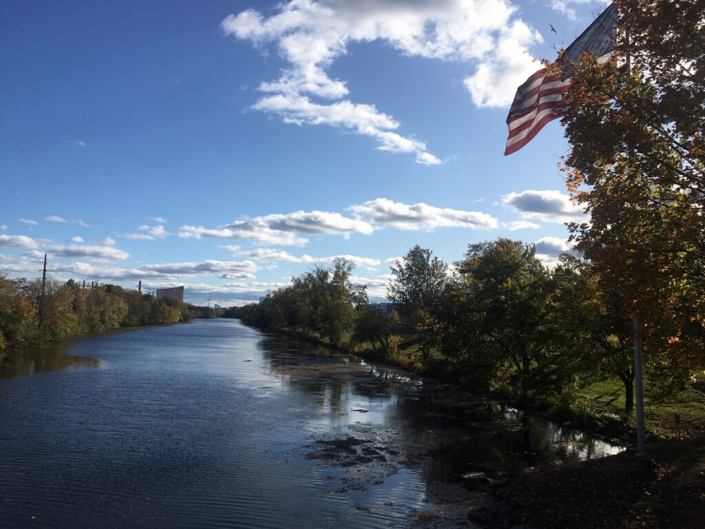A river with trees and clouds in the sky.